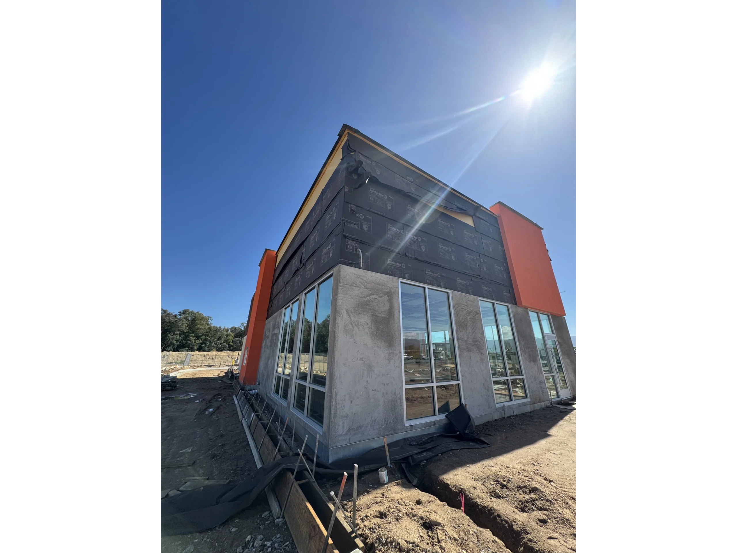 House under construction with the sun shining brightly in the background