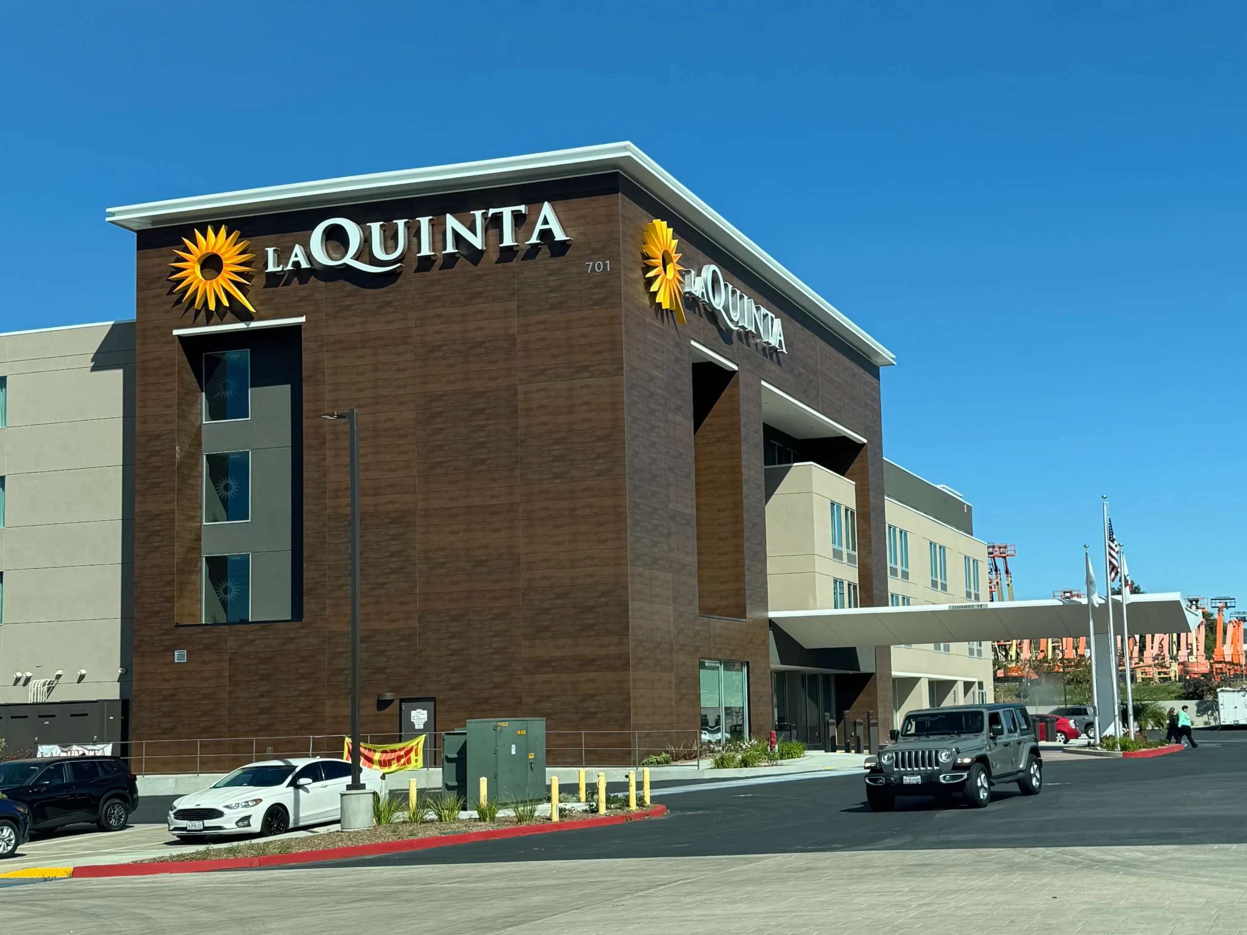 & Suites by, with a few vehicles on the road in front of the building